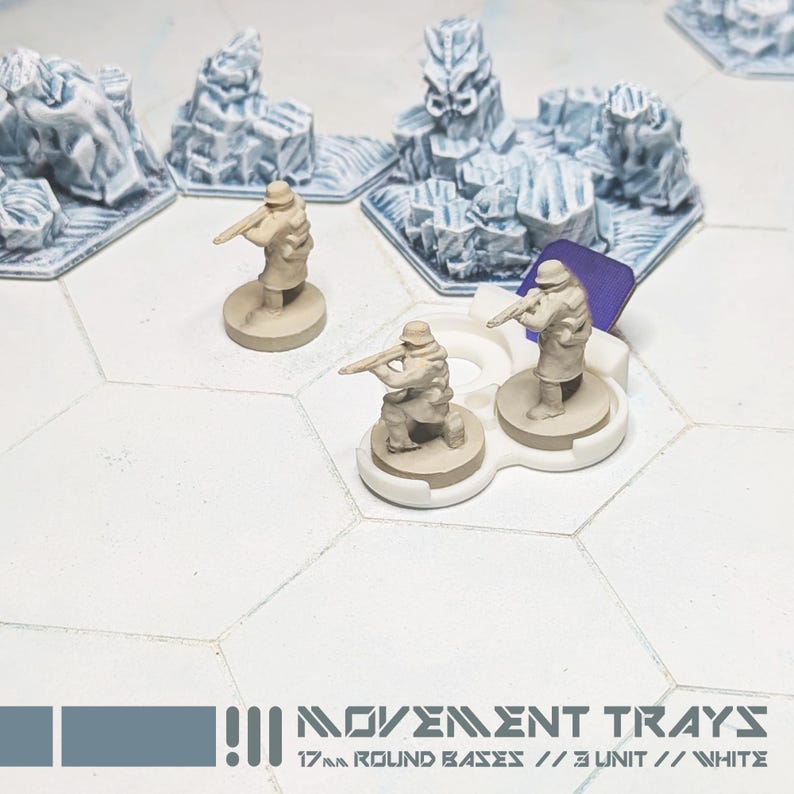 以下が含まれることがあります： ミニチュア兵士と地形を備えたテーブルトップウォーゲームのシーン。フィギュアはタン色で、ライフルを構え、白い丸いベースに配置されています。地形には白と青の氷の形成が含まれます。「MOVEMENT TRAYS」と「17mm ROUND BASES // 3 UNIT // WHITE」の文字が見えます。