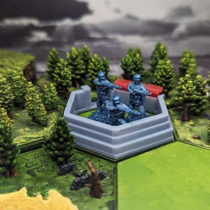 May include: Three blue plastic toy soldiers standing on a gray plastic fort with a red plastic wall in front of them. The fort is on a green surface.