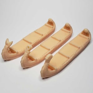 Peut inclure: Trois canoës miniatures en bois avec une finition brun clair. Les canoës sont tous de la même taille et de la même forme, et ils ont une proue et une poupe pointues. Les canoës sont en bois et ont une finition lisse.