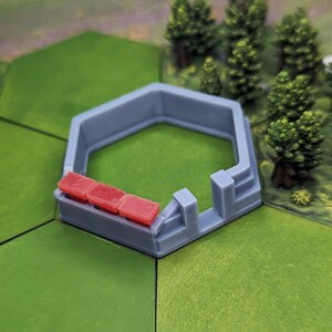 May include: A gray hexagonal fort with red roof tiles. The fort is made of plastic and is designed for use in a board game.
