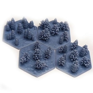Puede incluir: Cuatro fichas hexagonales de juego de color gris azulado. Cada ficha presenta una variedad de pequeños árboles impresos en 3D detallados. Los árboles están dispuestos de forma aleatoria en cada ficha.