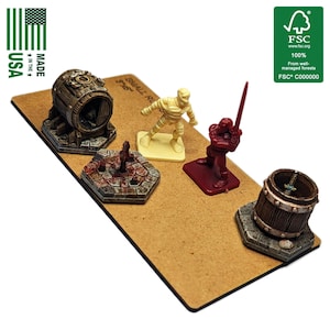 Könnte beinhalten: Miniatur-Fantasy-Spielsteine, darunter zwei Fässer, ein Brunnen, eine Mumie und ein Ritter mit einem Schwert, sind auf einer braunen Oberfläche angeordnet. Die Teile werden in den USA hergestellt und sind FSC-zertifiziert.
