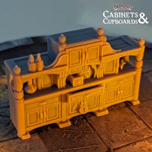 Pode incluir: Um arm&aacute;rio de madeira em miniatura detalhado com uma gaveta e portas, pintado em uma cor marrom quente. Tem uma prateleira superior e detalhes decorativos, perfeito para jogos de mesa.