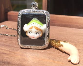 Creepy cute vintage Dutch doll art necklace with porcelain doll arm with silver case. Statement jewellery and unique one of a kind necklace.