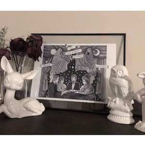 May include: A black and white print in a black frame depicting a group of people sitting around a table with a ghost hovering above them. The print reads "Do the Spirits Return" and is framed with a black frame.