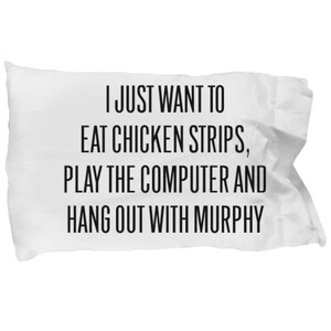 May include: White pillow with black text that reads "I just want to eat chicken strips, play the computer and hang out with Murphy."