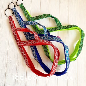 May include: Three colorful dog leashes with geometric patterns. The leashes are red, blue, and green with white accents.