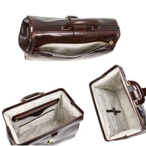 May include: A brown leather doctor's bag with a brass clasp and zippered compartments. The bag is open and the interior is lined with a cream fabric with a repeating pattern.