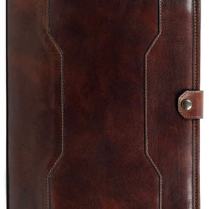 May include: A brown leather portfolio with a flap closure and a metal button. The portfolio has a stitched design and a textured surface.