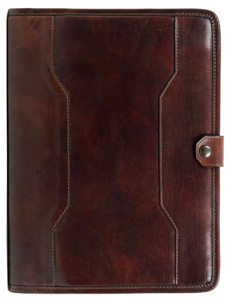 May include: A brown leather portfolio with a flap closure and a metal button. The portfolio has a stitched design and a textured surface.