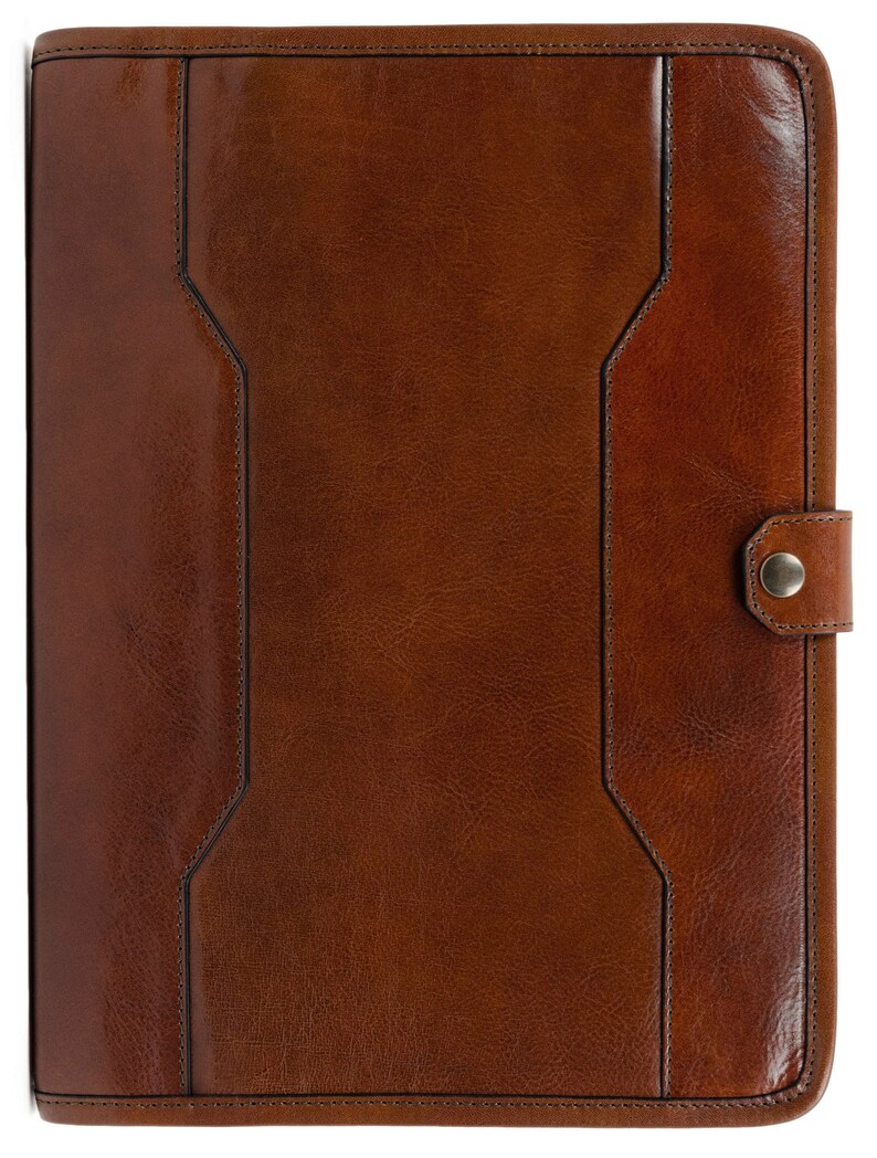 May include: A brown leather portfolio with a flap closure and a metal button. The portfolio has a textured surface and a stitched design.