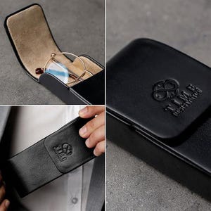 May include: A black leather glasses case featuring a fold-over flap with a debossed logo that reads TIME RESISTANCE. The interior is lined with a light tan material and contains a pair of round-framed glasses with thin metallic rims.