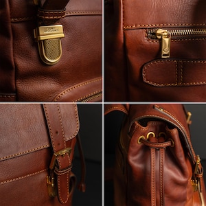 K&ouml;nnte beinhalten: Ein brauner Lederrucksack mit goldfarbenen Metallbeschl&auml;gen, darunter ein Druckknopfverschluss mit der Gravur TIME RESISTANCE, eine Rei&szlig;verschlusstasche mit Marken-Zipper sowie verstellbare Riemen mit Schnallen und Kordelzugdetails.