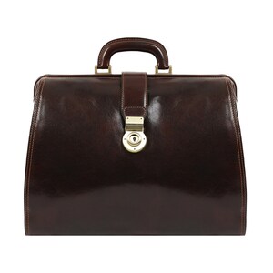 May include: A brown leather doctor's bag with a brass lock and handle.