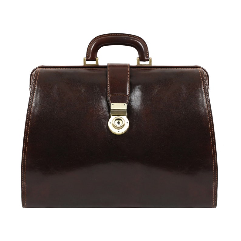 May include: A brown leather doctor's bag with a brass lock and handle.