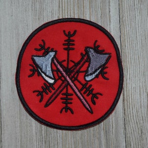 May include: A red circular patch with a black embroidered design of two crossed axes with a stylized sun symbol in the center.