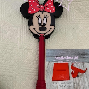 Peut inclure: Un stylo sur le th&egrave;me de Minnie Mouse, rouge et noir, avec un n&oelig;ud &agrave; pois rouges. Le stylo a une base rouge assortie et comprend un porte-cartes arri&egrave;re rouge. Le texte "Creative Jems GA" et "Back Card holder for Girl Mouse" sont visibles.