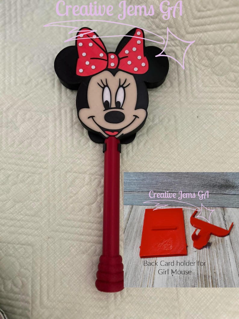 Peut inclure: Un stylo sur le th&egrave;me de Minnie Mouse, rouge et noir, avec un n&oelig;ud &agrave; pois rouges. Le stylo a une base rouge assortie et comprend un porte-cartes arri&egrave;re rouge. Le texte "Creative Jems GA" et "Back Card holder for Girl Mouse" sont visibles.