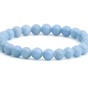May include: A light blue beaded bracelet. The bracelet is made of round, polished beads. The beads are a soft, pastel blue color. The bracelet is displayed on a white background.