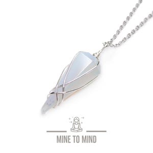 May include: A light blue crystal pendulum pendant necklace with silver-coloured wire wrapping and a delicate silver chain. The image includes the text "MINE TO MIND" at the bottom.