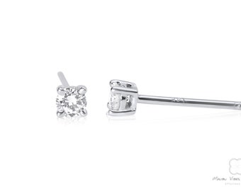 May include: A pair of silver stud earrings with a small, clear round gemstone in the center of each earring.
