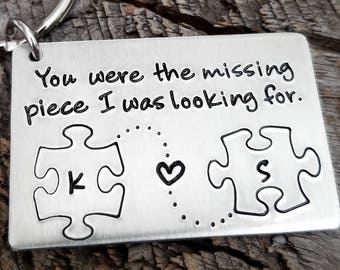 May include: Silver keychain with a puzzle piece design and the inscription "You were the missing piece I was looking for." The puzzle pieces have the letters "K" and "S" inside.
