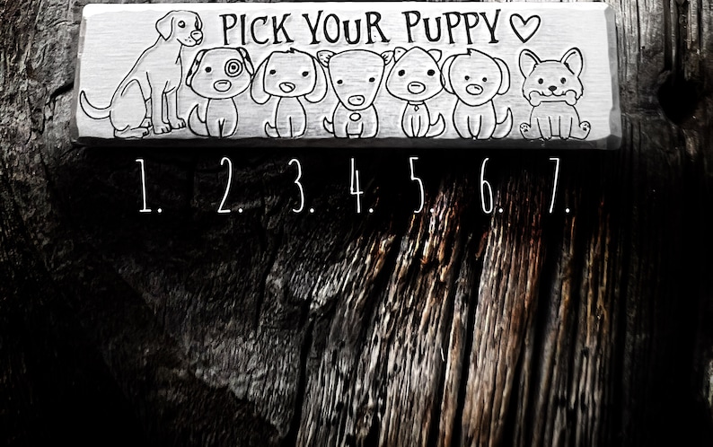 May include: A rectangular wooden sign with the text "PICK YOUR PUPPY" and seven cartoon dog illustrations. Each dog has a unique design. Numbers 1 through 7 are below the dogs. The sign is in black and white.