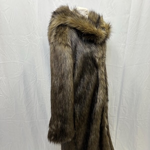 May include: A long brown faux fur coat with a large hood. The coat is made of soft, plush fabric and has a relaxed fit.