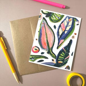 Puede incluir: Tarjeta de felicitación con diseños abstractos de hojas en rosa, azul, verde y naranja. También se ven un bolígrafo rosa, un bolígrafo amarillo, un sobre marrón y un rollo de cinta adhesiva amarilla.