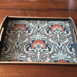 May include: A black wooden serving tray with gold trim and a floral design in shades of blue, beige, and orange.