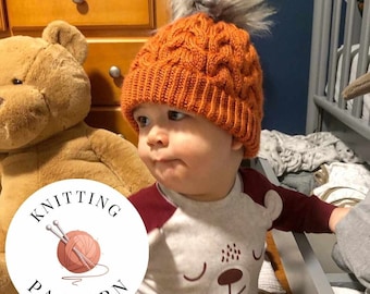 May include: A baby wearing a knitted orange beanie with a gray pom pom and a white and red long-sleeved shirt with a bear design. The beanie has a cable knit pattern. The image includes a white circle with the text "Knitting Pattern" and a drawing of knitting needles and yarn.