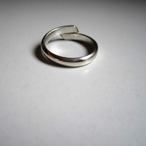 May include: A silver ring with a simple, smooth design. The ring is made of metal and has a polished finish.