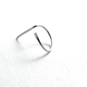 May include: A silver metal ring with a simple, curved design.
