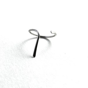 May include: A silver ring with a unique, twisted design. The ring is made of a single piece of metal that is bent into a loop and then twisted to create a unique shape.