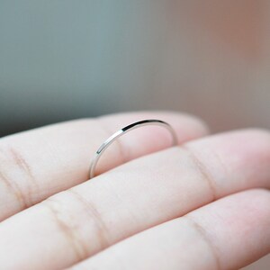 Pu&ograve; includere: Un anello sottile in argento, indossato su un dito.