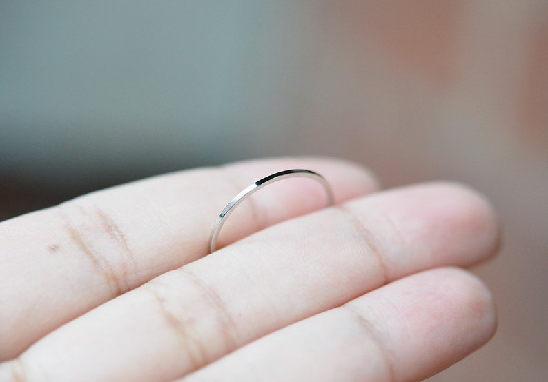 Pu&ograve; includere: Un anello sottile in argento, indossato su un dito.
