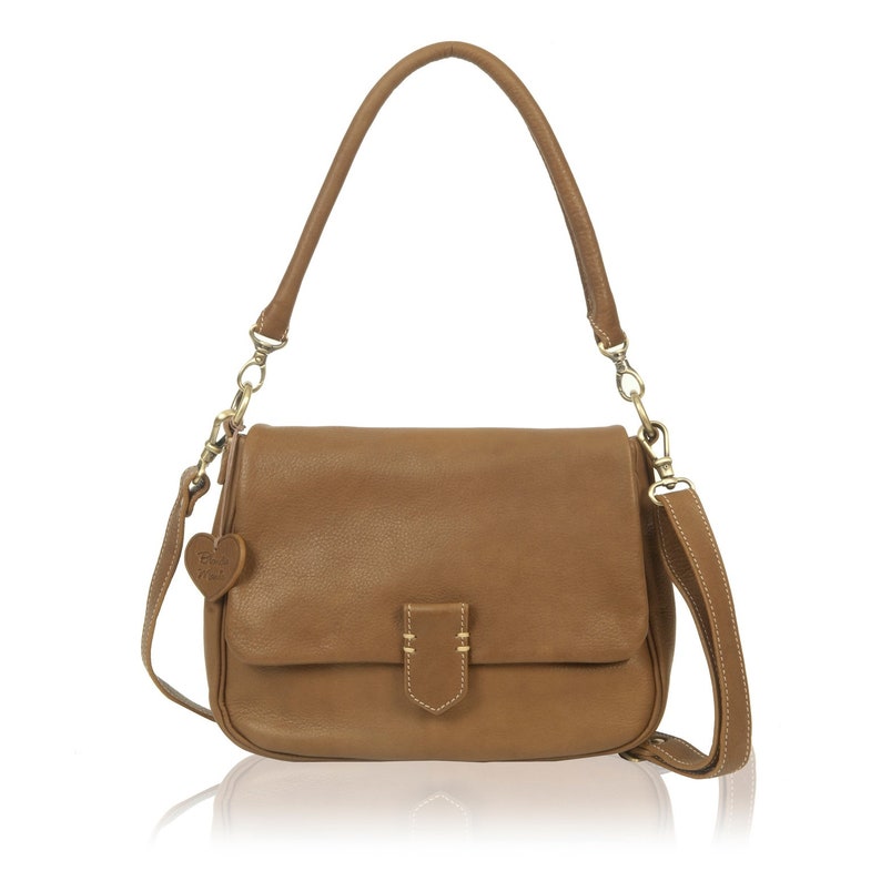 May include: A brown leather shoulder bag with a flap closure and a small heart-shaped charm. The bag has a gold-toned chain strap and a long adjustable shoulder strap.