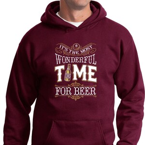 May include: Burgundy hooded sweatshirt with a white graphic that says "It's the most wonderful time for beer" with a beer bottle illustration.