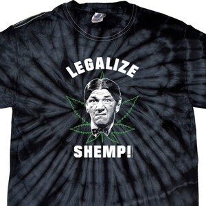May include: A black tie-dye t-shirt with a green marijuana leaf and a cartoon image of a man with the text "Legalize Shemp!" printed on the front.