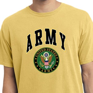 May include: A yellow t-shirt with the word "ARMY" in black letters above the United States Army seal. The seal is a green circle with a bald eagle, stars, and the words "UNITED STATES ARMY".