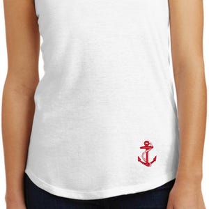 May include: White tank top with a red anchor graphic on the front. The tank top is made of a soft, comfortable fabric and has a relaxed fit.