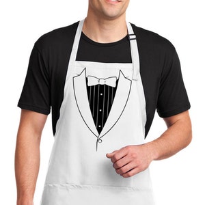 May include: White apron with a tuxedo design printed on the front. The tuxedo has a black bow tie, a white shirt with black vertical stripes, and a black lapel.