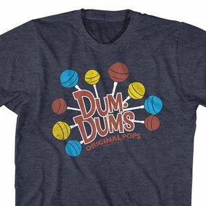 May include: A navy blue t-shirt with a vintage-style graphic of Dum Dums lollipops in red, yellow, and blue. The text "Dum Dums Original Pops" is printed below the lollipops.