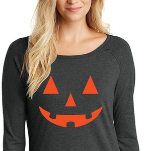 May include: A dark gray long-sleeved shirt with a bright orange jack-o'-lantern face graphic.