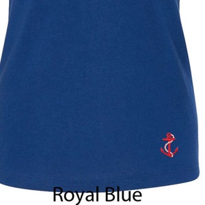 May include: A royal blue v-neck t-shirt with a small red anchor embroidered on the bottom right side.