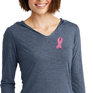 May include: A long-sleeved hooded shirt in a dark blue heather color with a pink ribbon embroidered on the left chest.