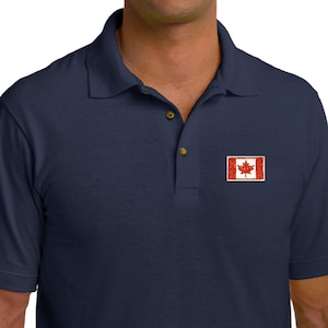 Op de afbeelding: Een donkerblauw poloshirt met een kleine Canadese vlag geborduurd op de linker borst.