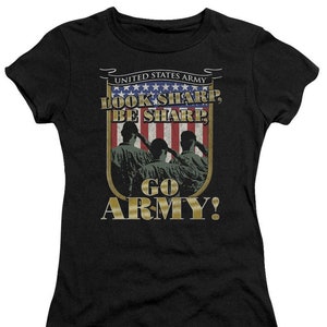 May include: Black t-shirt featuring a graphic with the text "UNITED STATES ARMY" above a shield design with the words "LOOK SHARP, BE SHARP" and "GO ARMY!". The shield design includes an American flag and silhouettes of soldiers saluting.