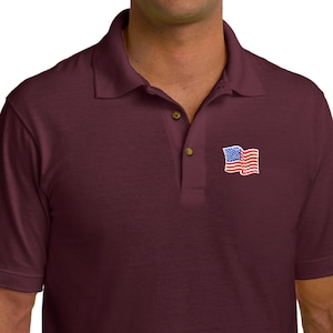 May include: A maroon polo shirt with a small embroidered American flag on the left chest.