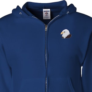 Può includere: Una felpa con cappuccio blu reale con zip e un'aquila calva ricamata in bianco sul petto sinistro.